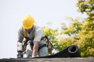 Worker putting Shingles on roof